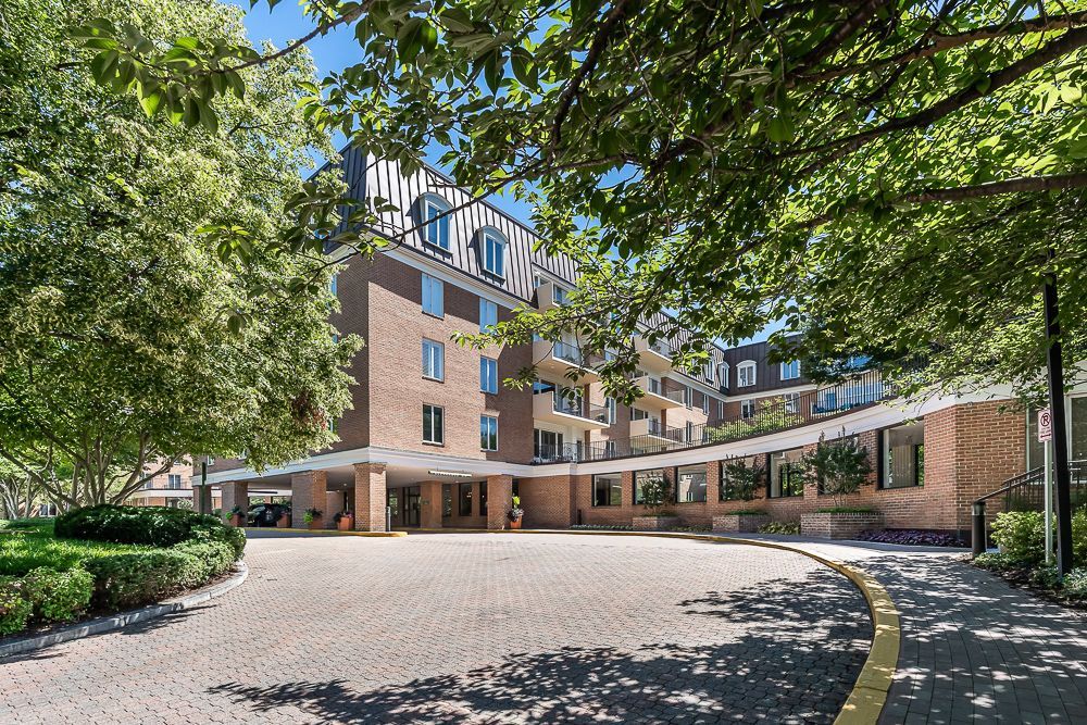 A large brick building with a parking lot in front of it surrounded by trees outdoor shoot on sunny day in downtown chevy chase shoot by craig westerman and team
