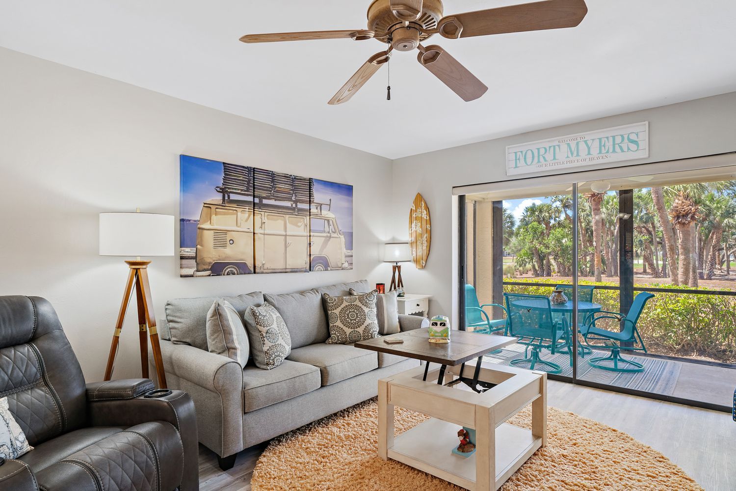 Cozy living room featuring a comfortable couch, stylish chair, sleek coffee table, and modern ceiling fan, captured in a Fort Myers home by expert real estate photographers near you.