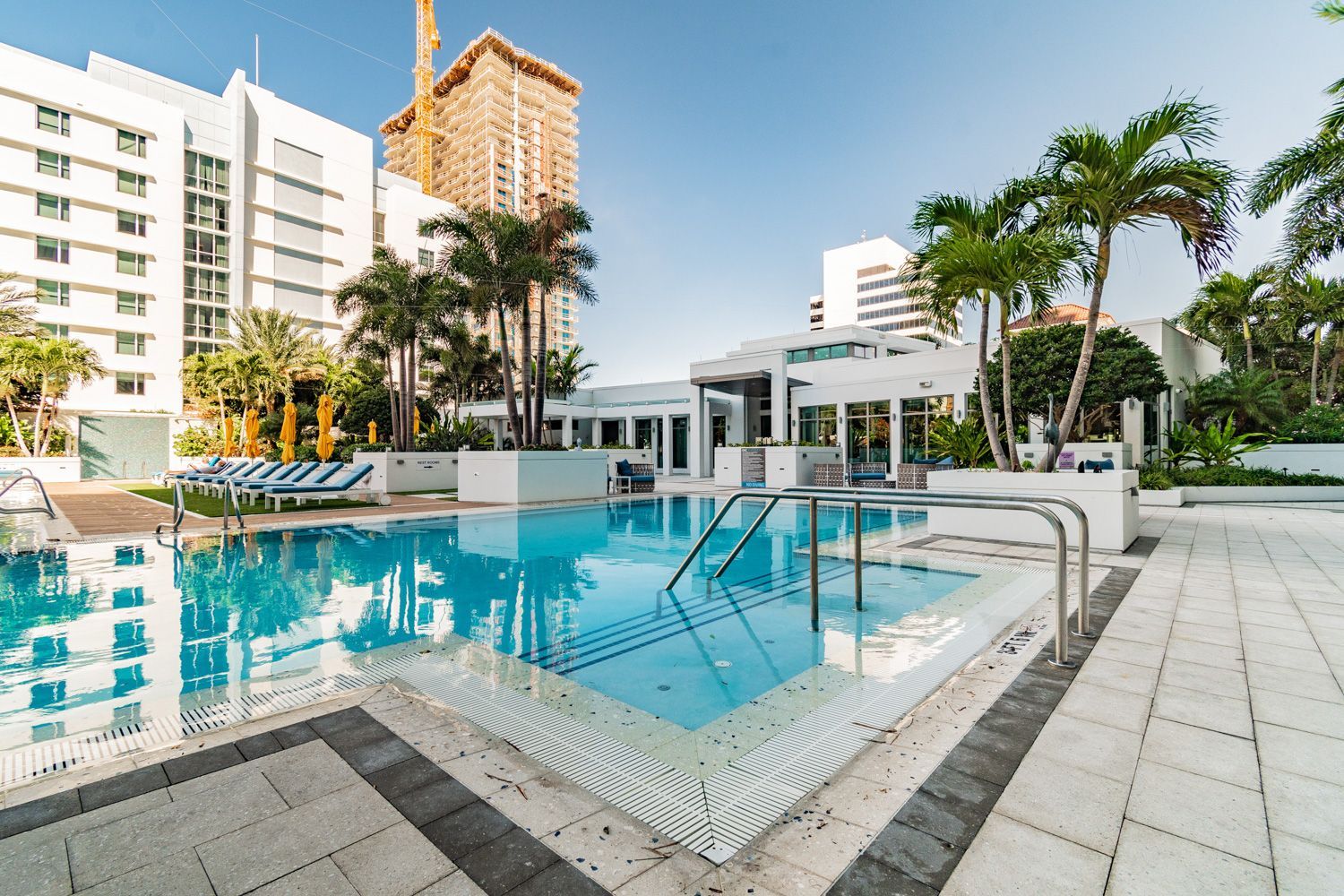 A large swimming pool is surrounded by palm trees and buildings at beautiful St. Petersburg, Fl hotel shoot by Craig Westerman.