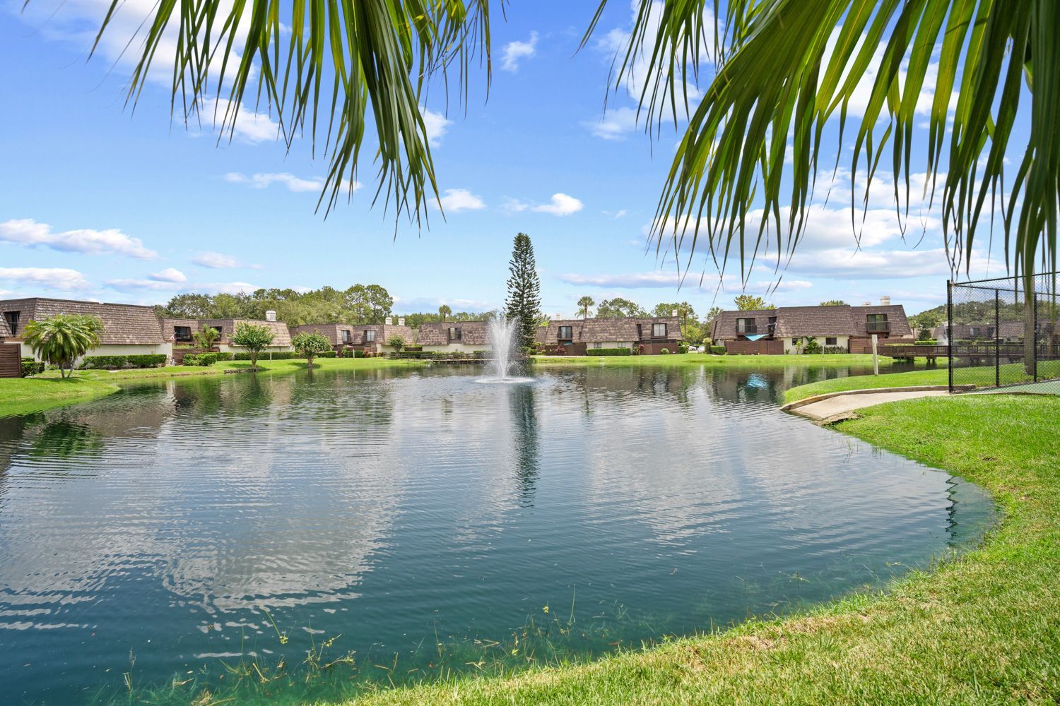 A serene pond with a fountain in the center, located in Tampa, Florida. Shoot by photographers near you.