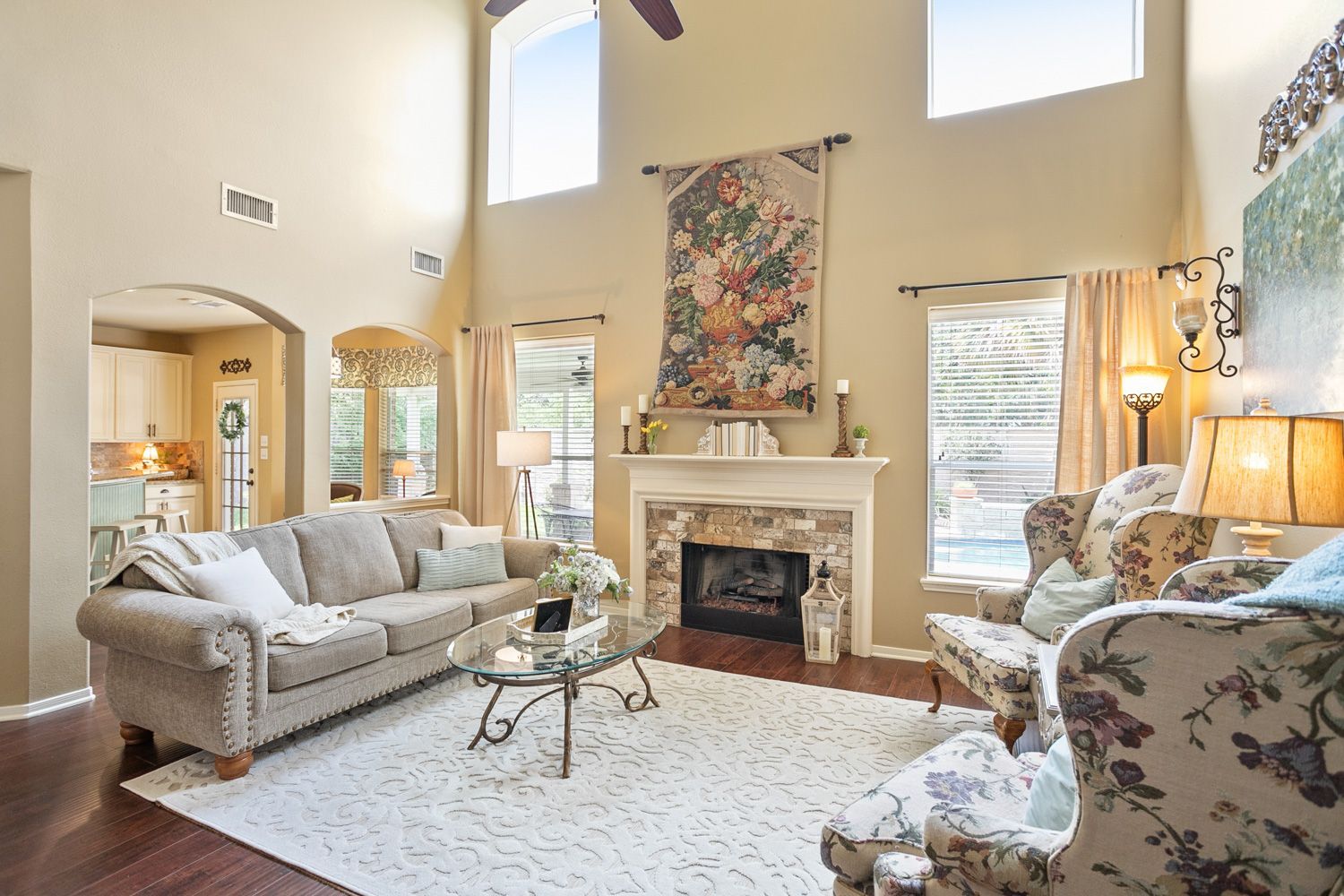 Beautiful Houston living room with a couch , chairs , coffee table and fireplace white shoot by Hometrack Real Estate Marketing Team 
