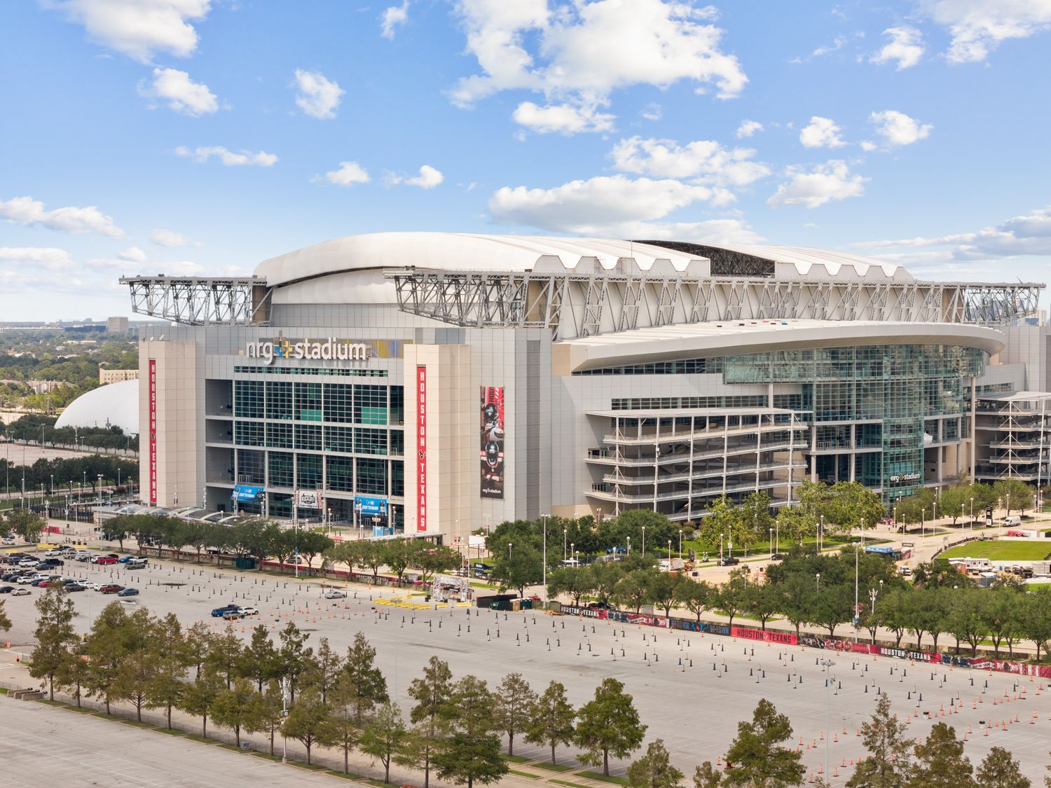 An drone shoot of NRG stadium surrounded by trees and cars by Hometrack team. 
