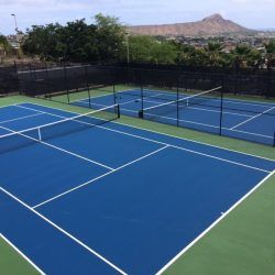 Blue tennis courts with Diamond Head in the background.