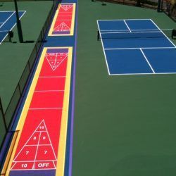 Overhead view of shuffleboard courts and pickleball courts on a green surface.