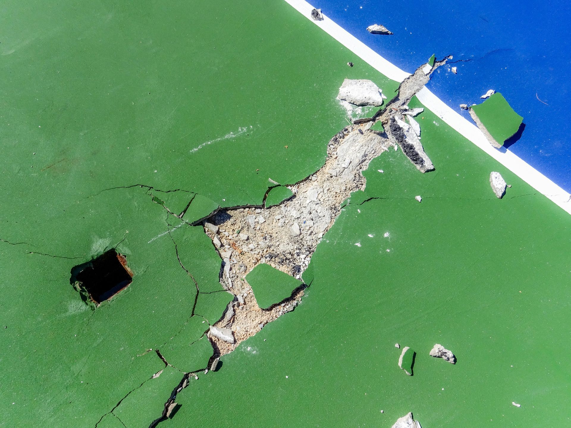 Exposed concrete wall with visible rebar grid; weathered, textured surface.