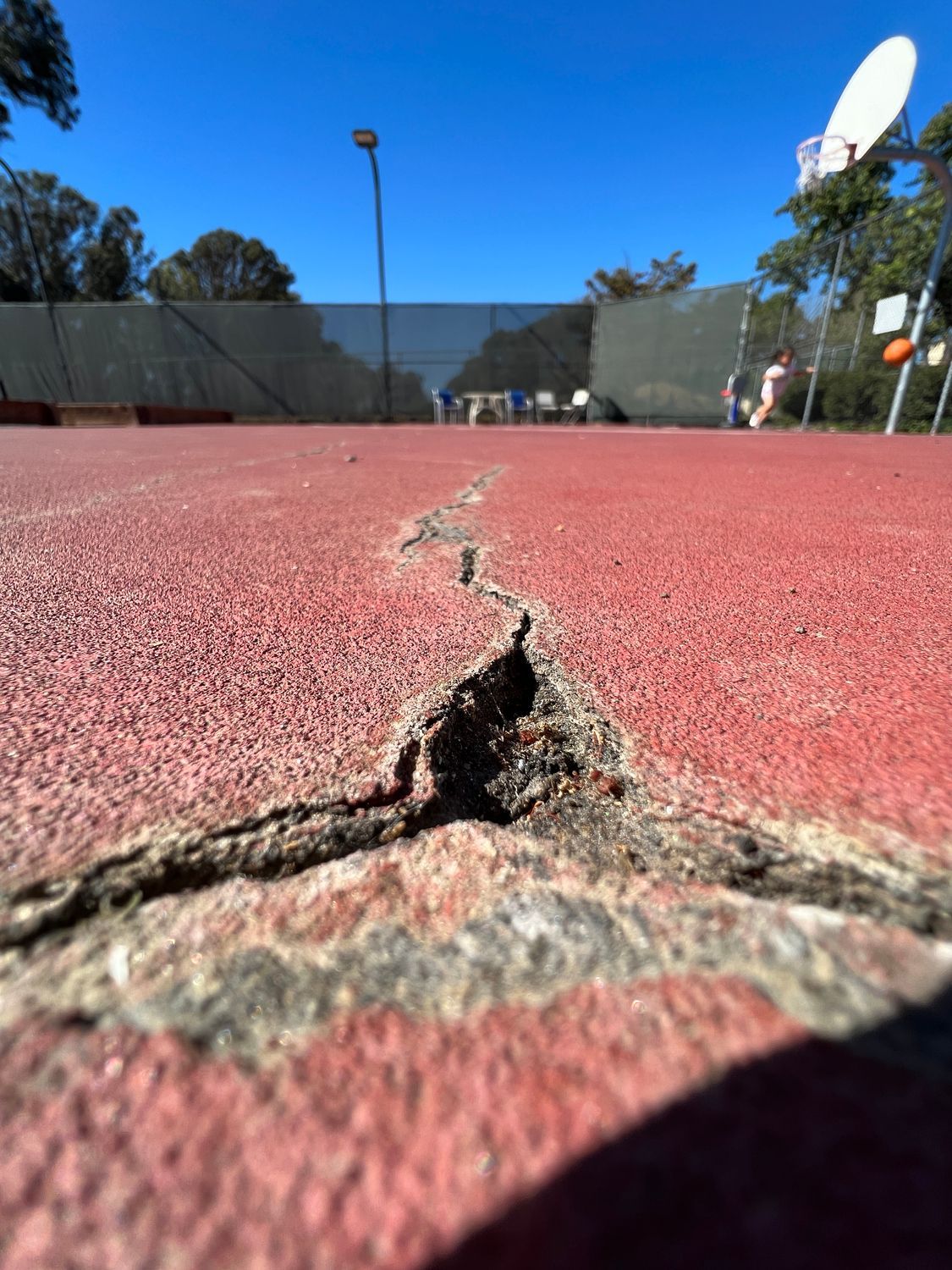 A large, jagged crack running down a yellow wall from ceiling to door frame.