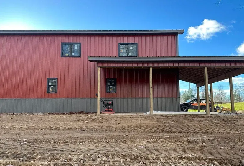 A red and gray building with a carport underneath it.