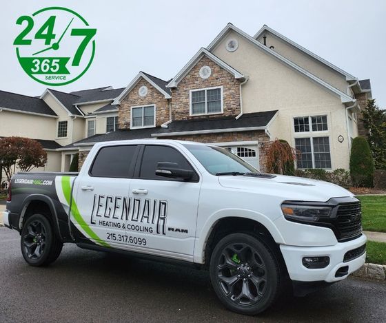 A white truck is parked in front of a large house.