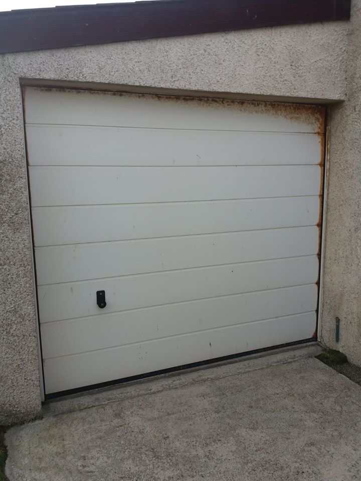 An old and rusted white garage door