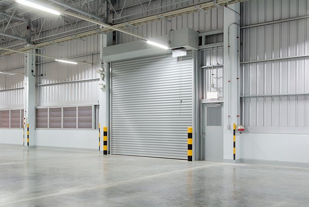 The inside of a warehouse with a large garage door