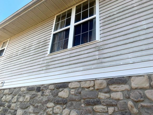 Pressure washing siding of house