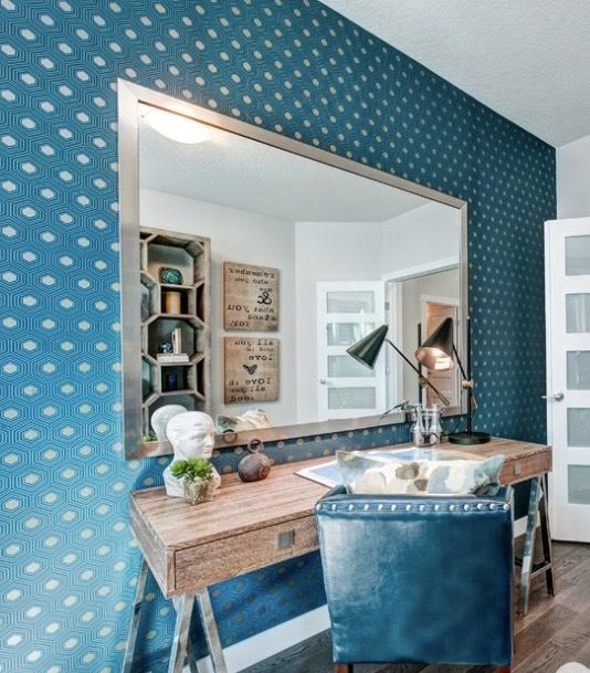 A room with a desk and chair and a large mirror