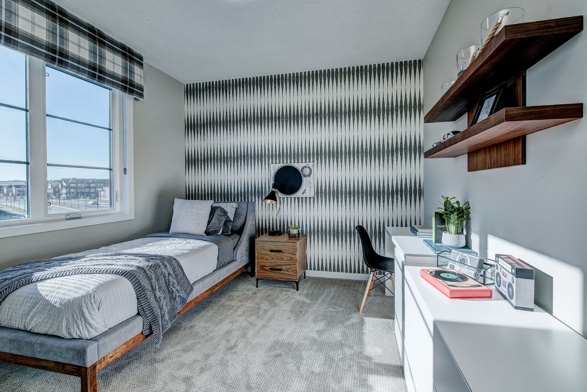 A bedroom with a bed , desk , shelves and a window.