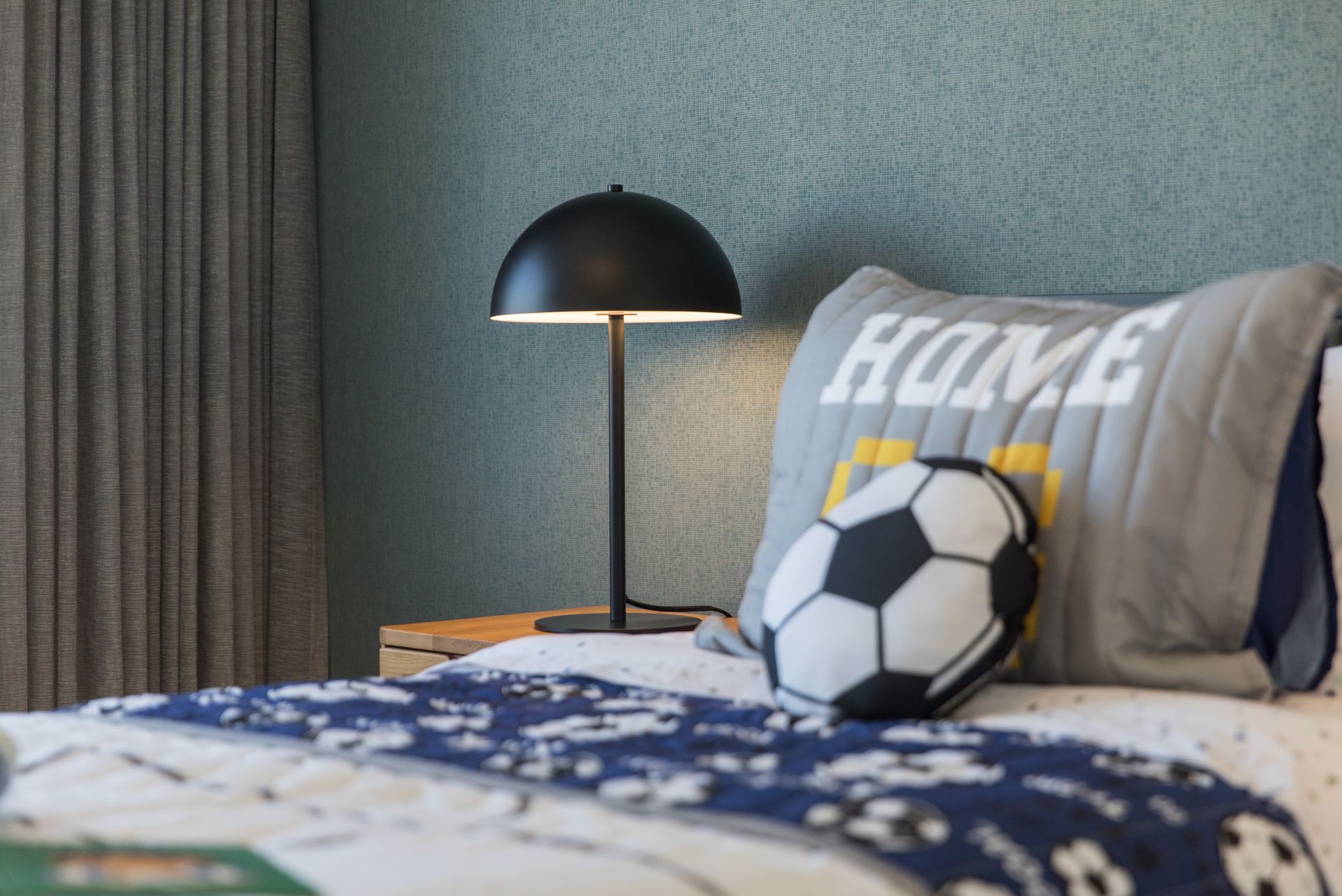 A bed with a pillow that says home on it