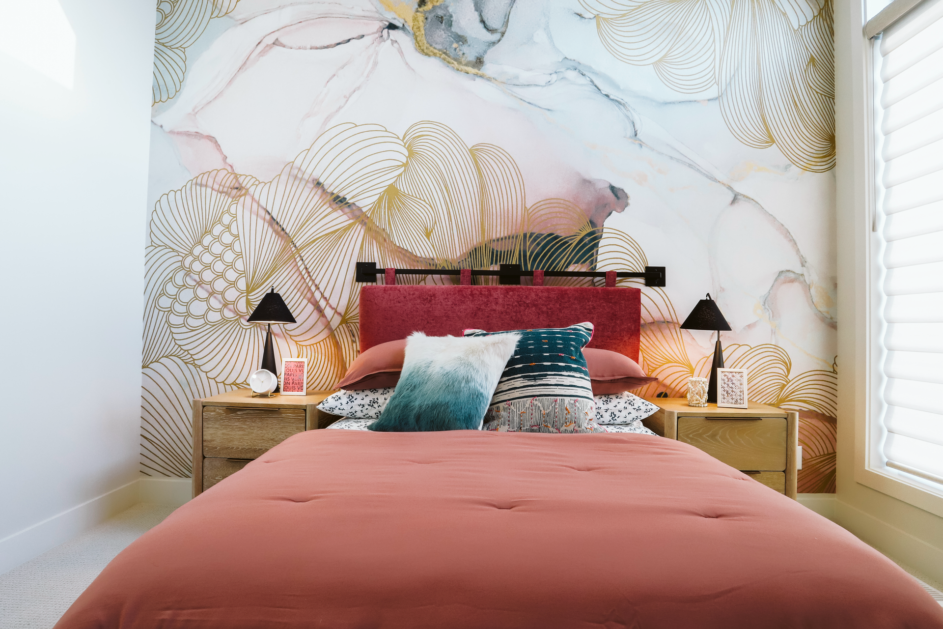 A bedroom with a bed , nightstands , and a painting on the wall.