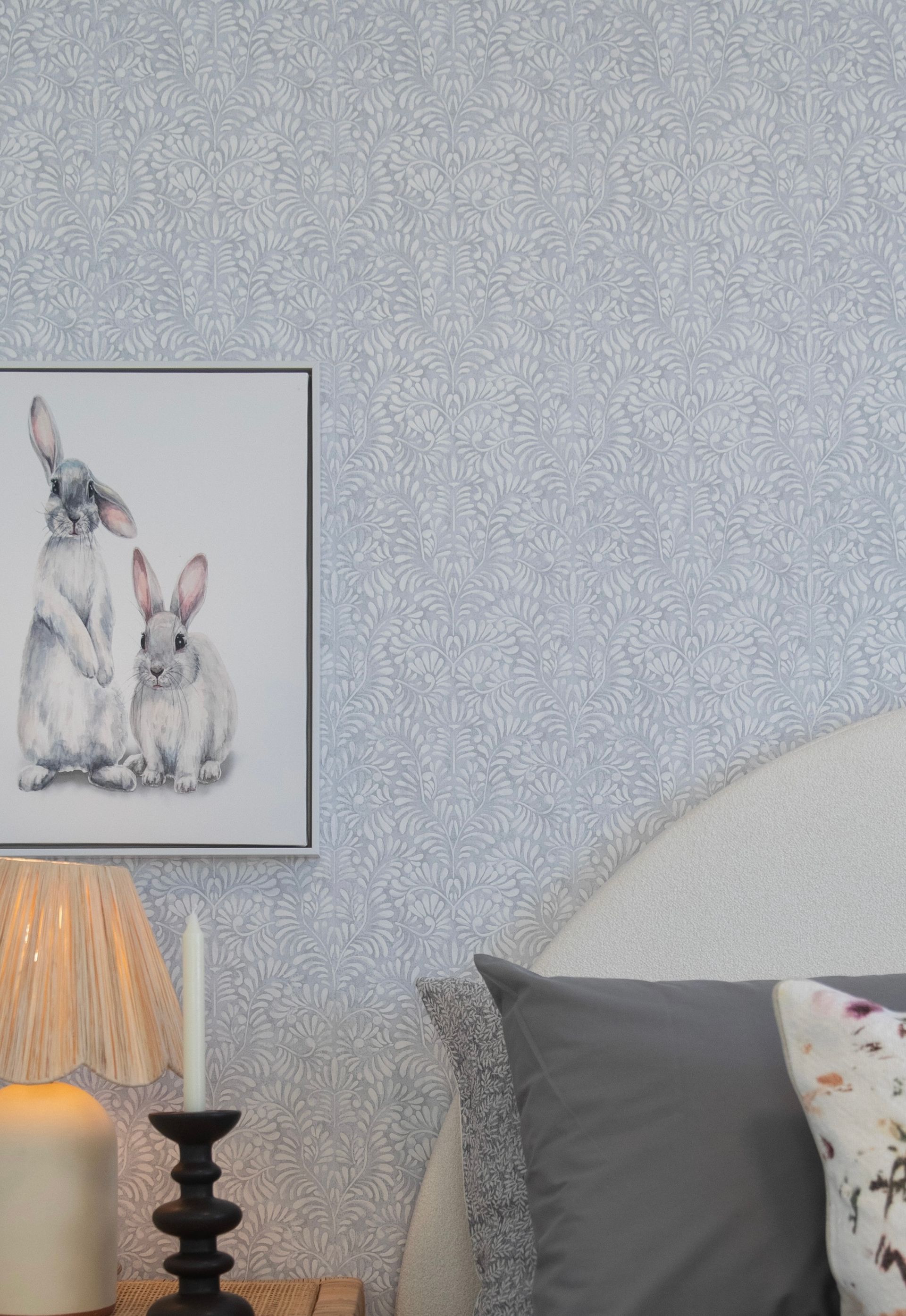 There is a picture of two rabbits on the wall above the bed.