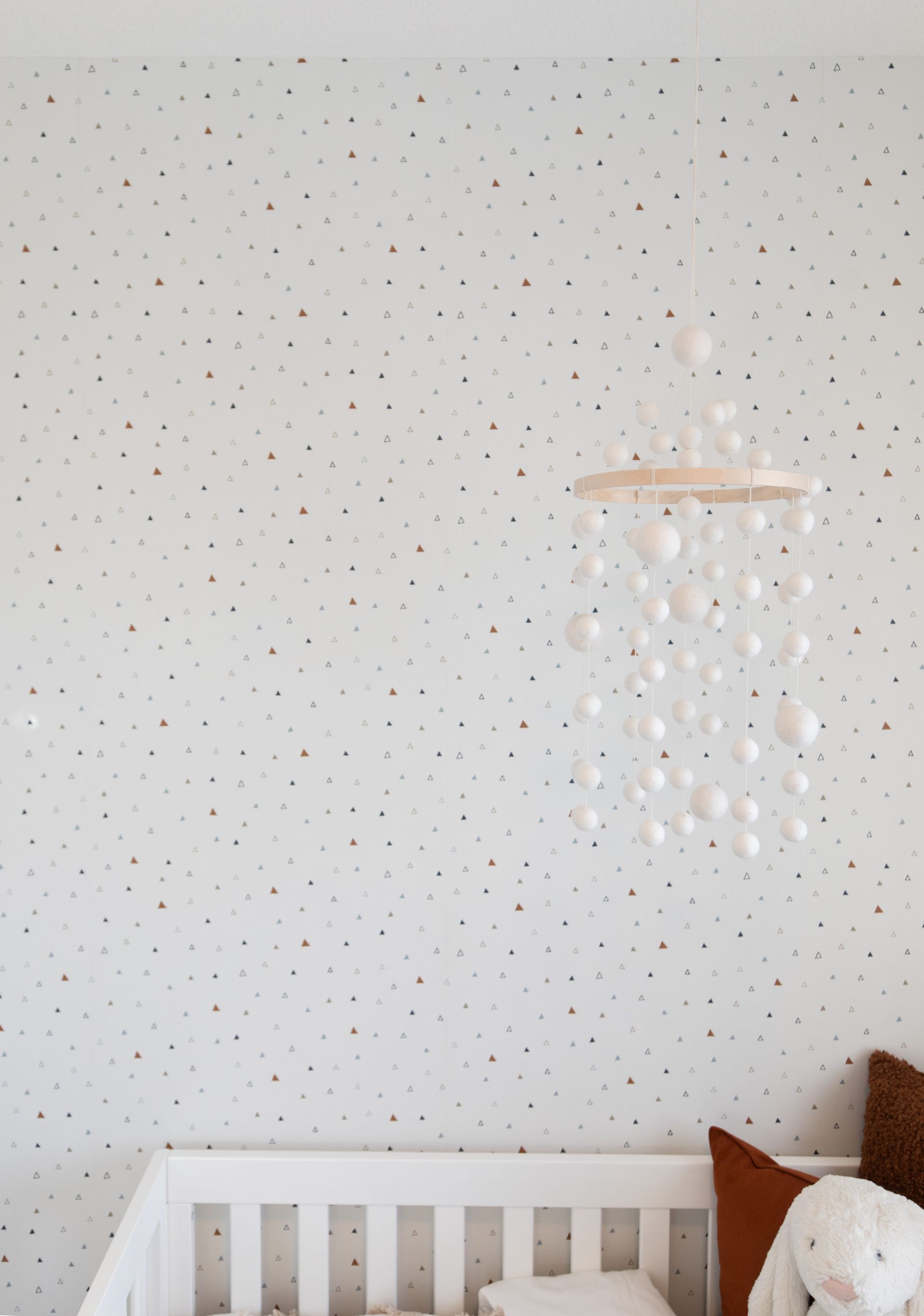 A baby 's room with a crib and a mobile