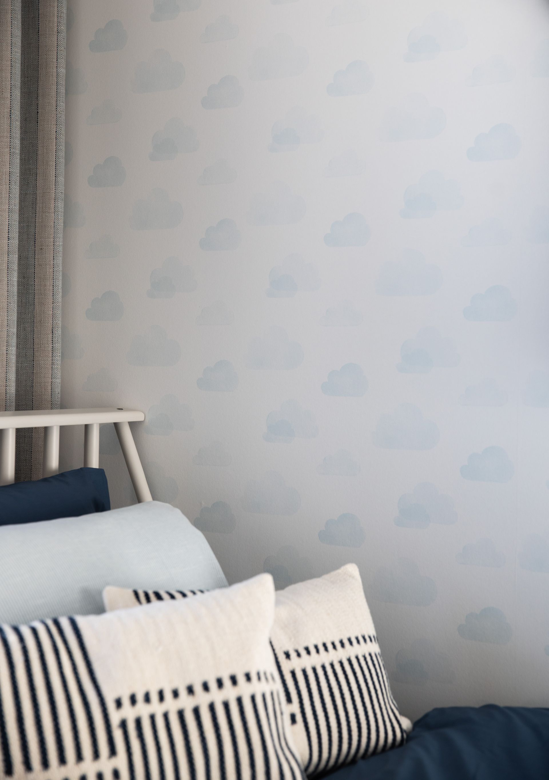 A bed with striped pillows on it in a bedroom.