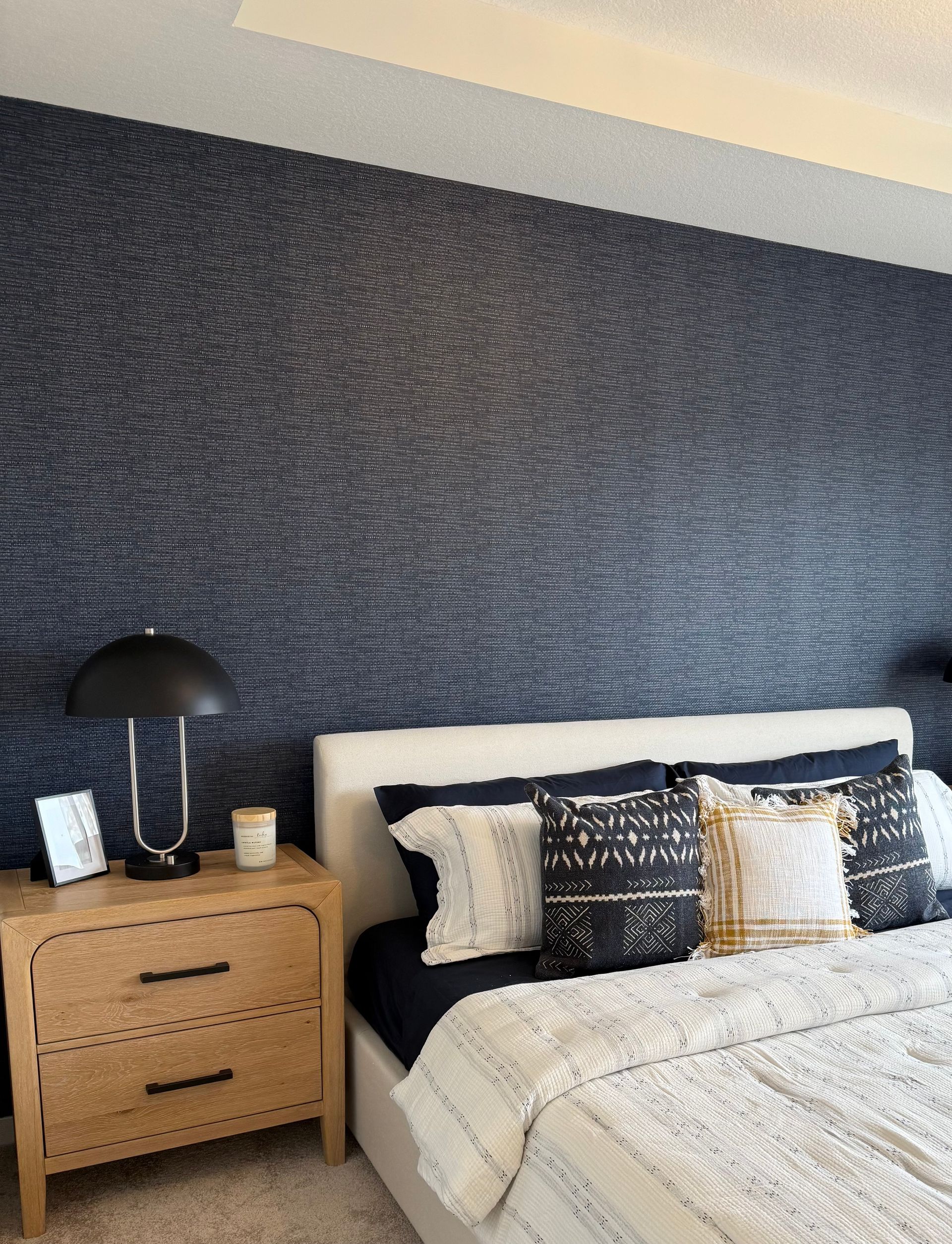 A bedroom with a large bed and a nightstand