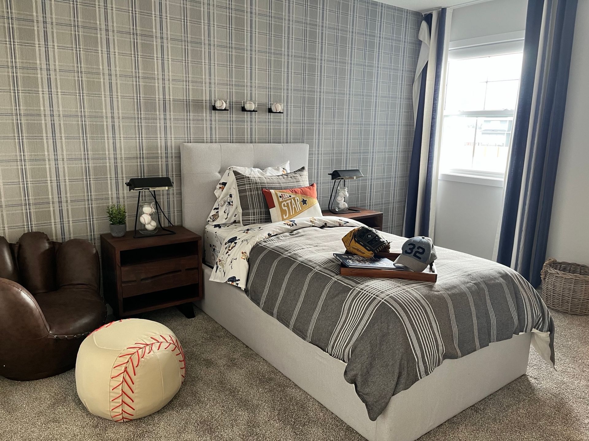 A bedroom with a bed , nightstand , chair and baseball ottoman.