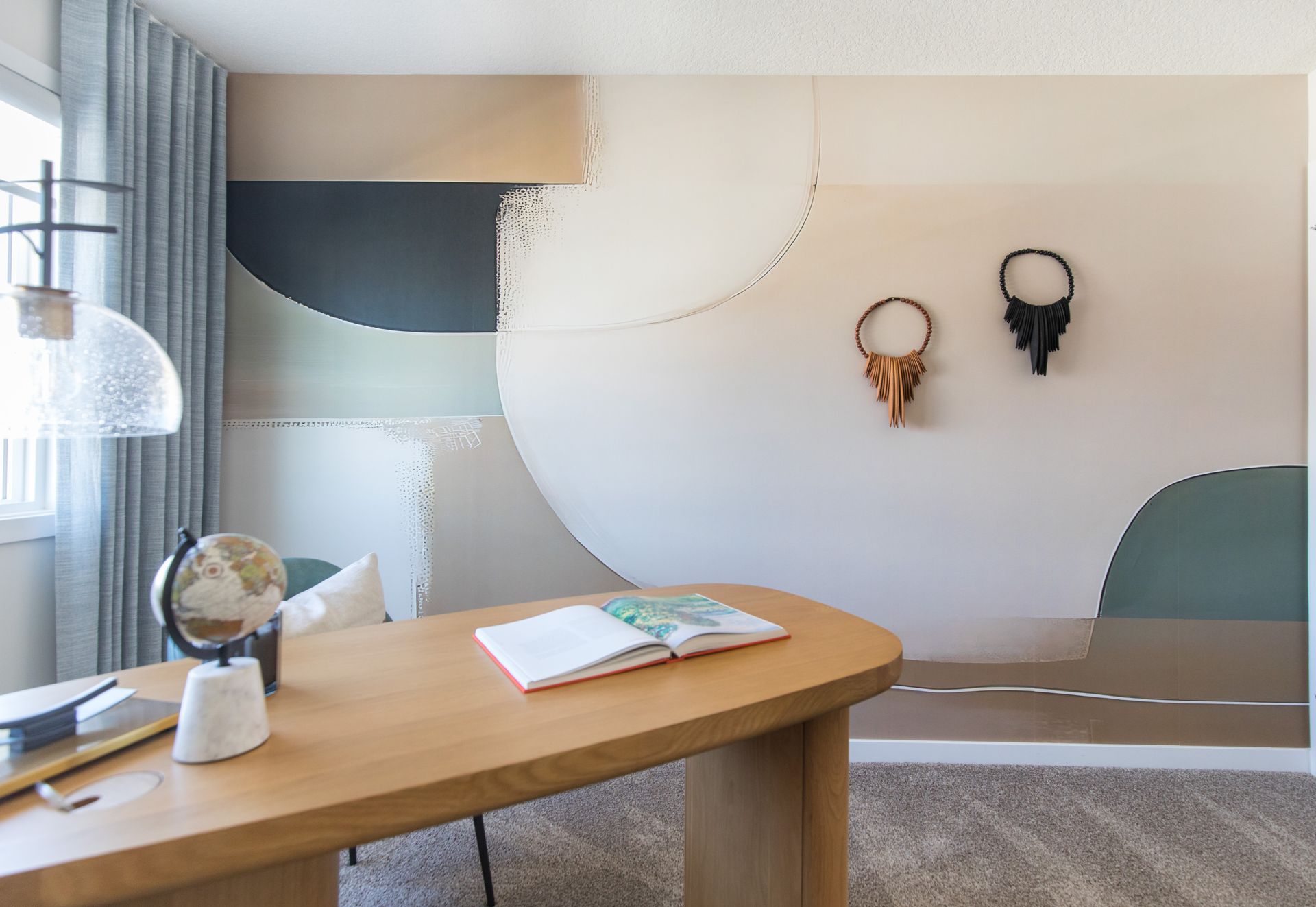 A home office with a wooden desk and a globe on it.