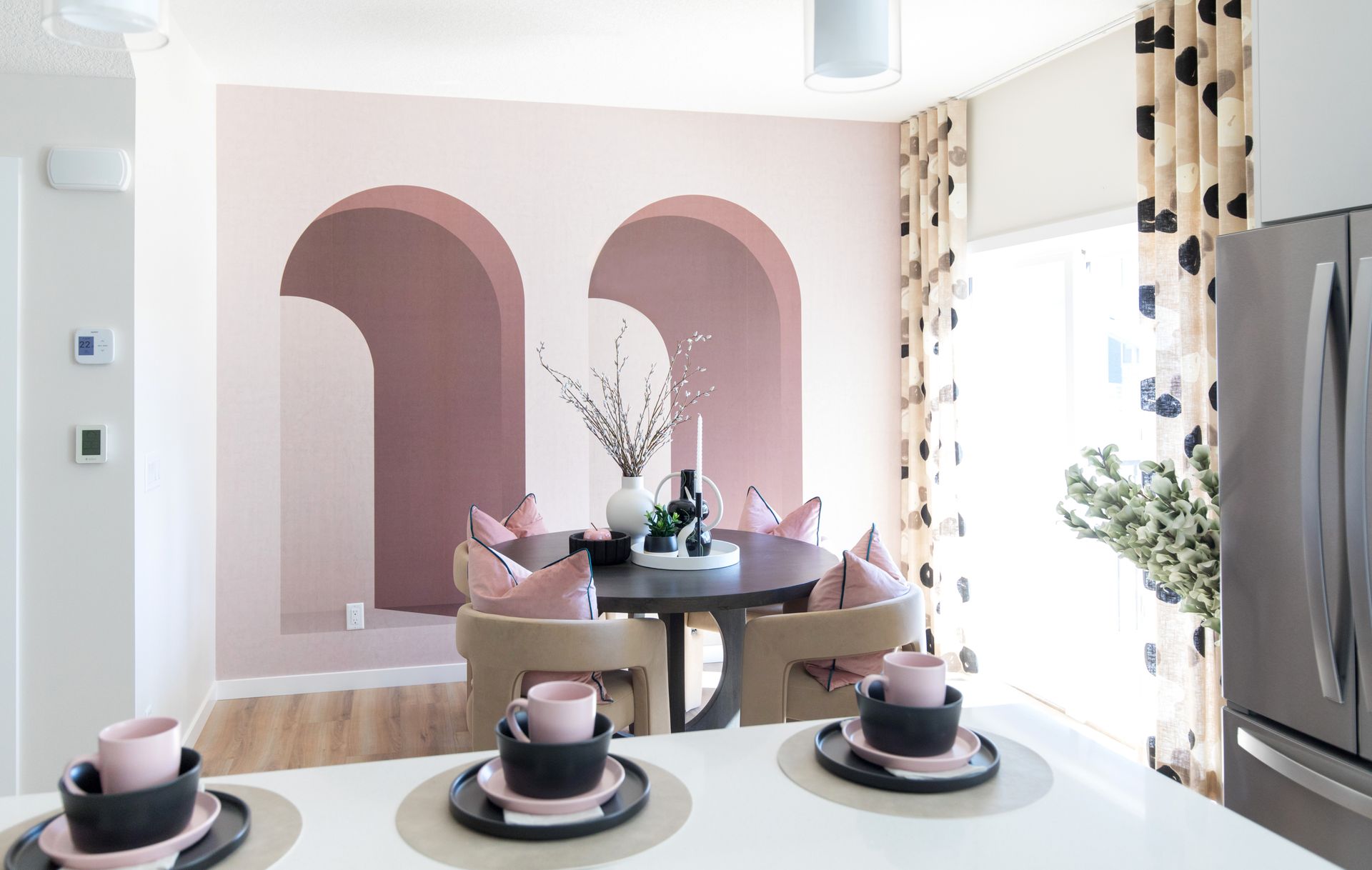 A dining room with a table and chairs and a refrigerator.