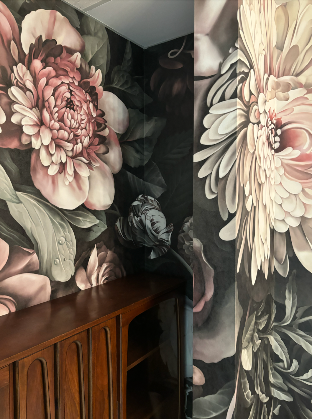 A room with a large floral wallpaper on the wall