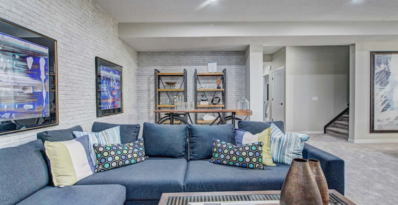 A living room with a blue couch and a flat screen tv.