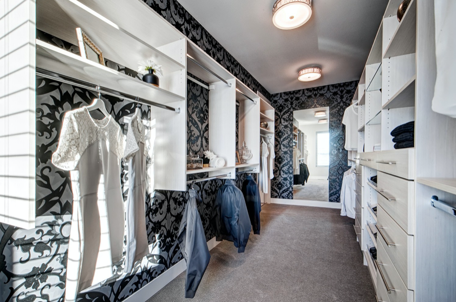 A walk in closet with black and white wallpaper