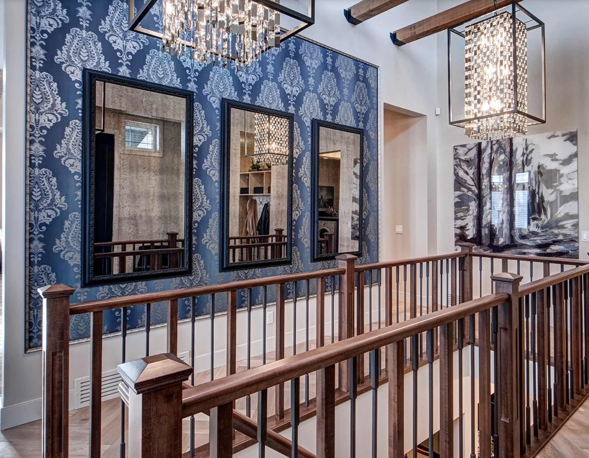 A staircase with a wooden railing and mirrors on the wall.