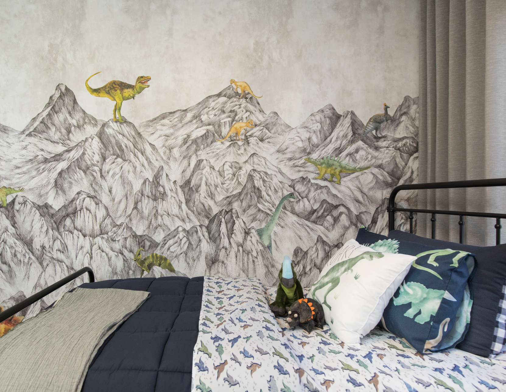 A bedroom with a bed and a painting of dinosaurs on the wall.