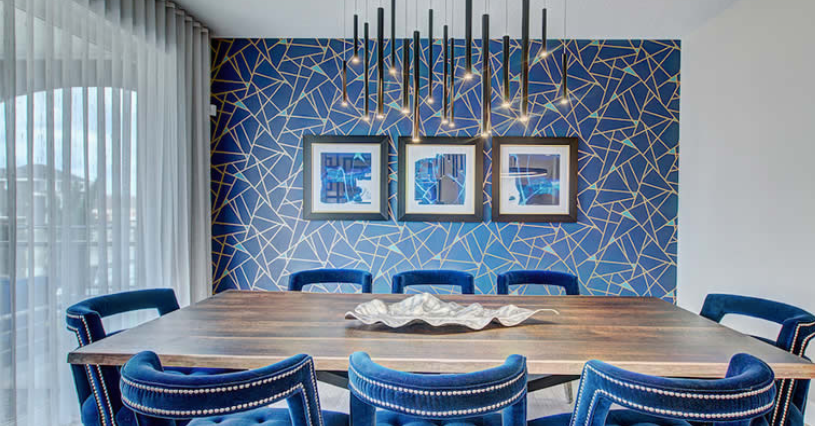 A dining room with a table and chairs and a blue wall.