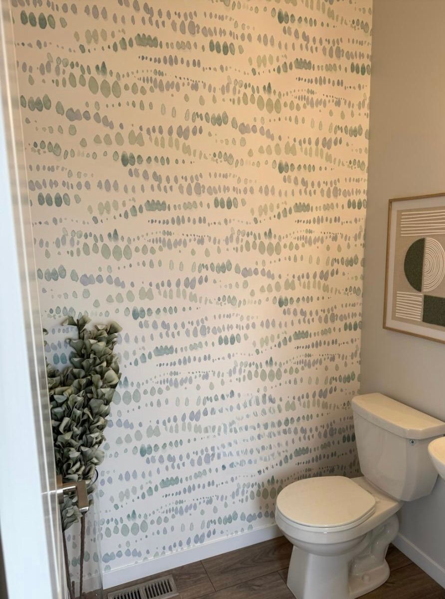 A bathroom with a toilet and a picture on the wall.