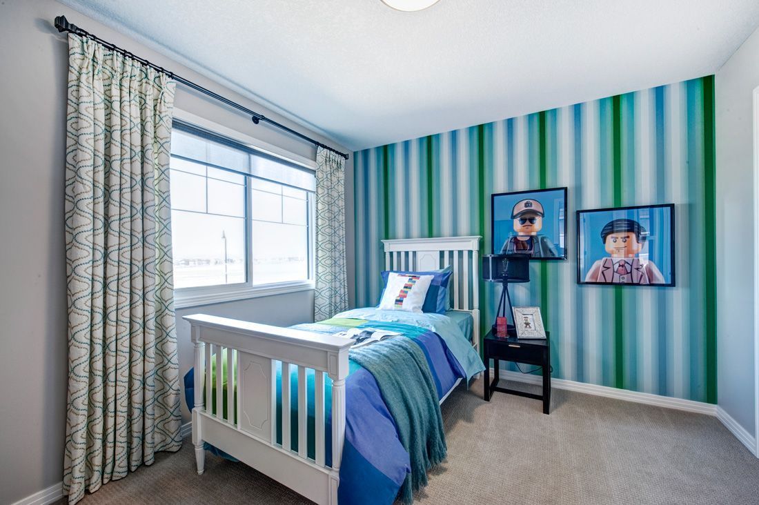 A bedroom with a bed and two pictures on the wall.