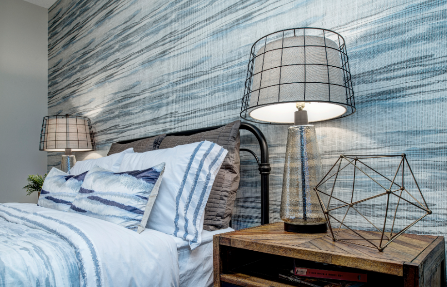 A bedroom with a bed , two lamps and a nightstand.