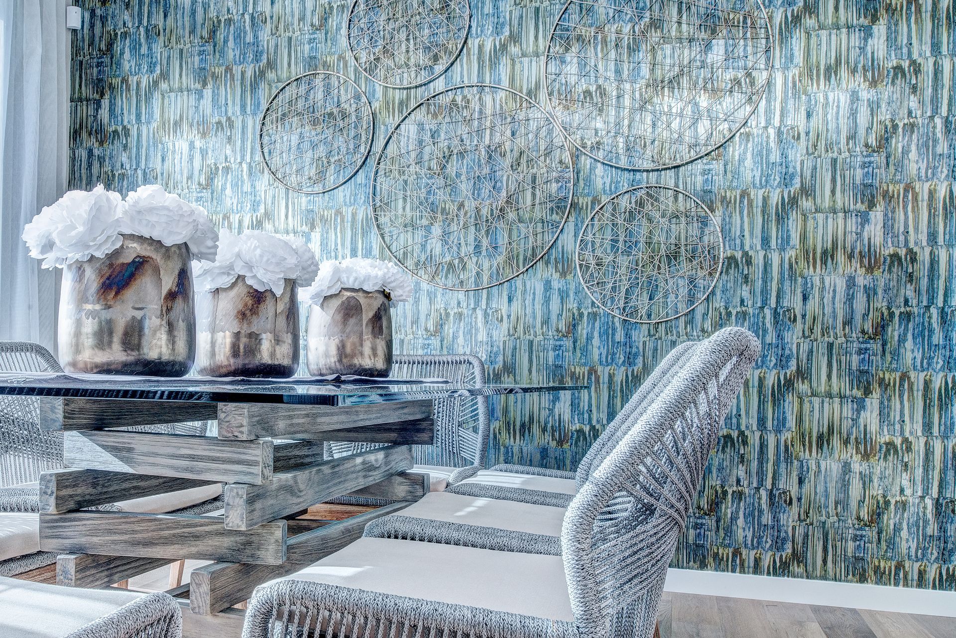 A dining room with a table and chairs and a blue wall.