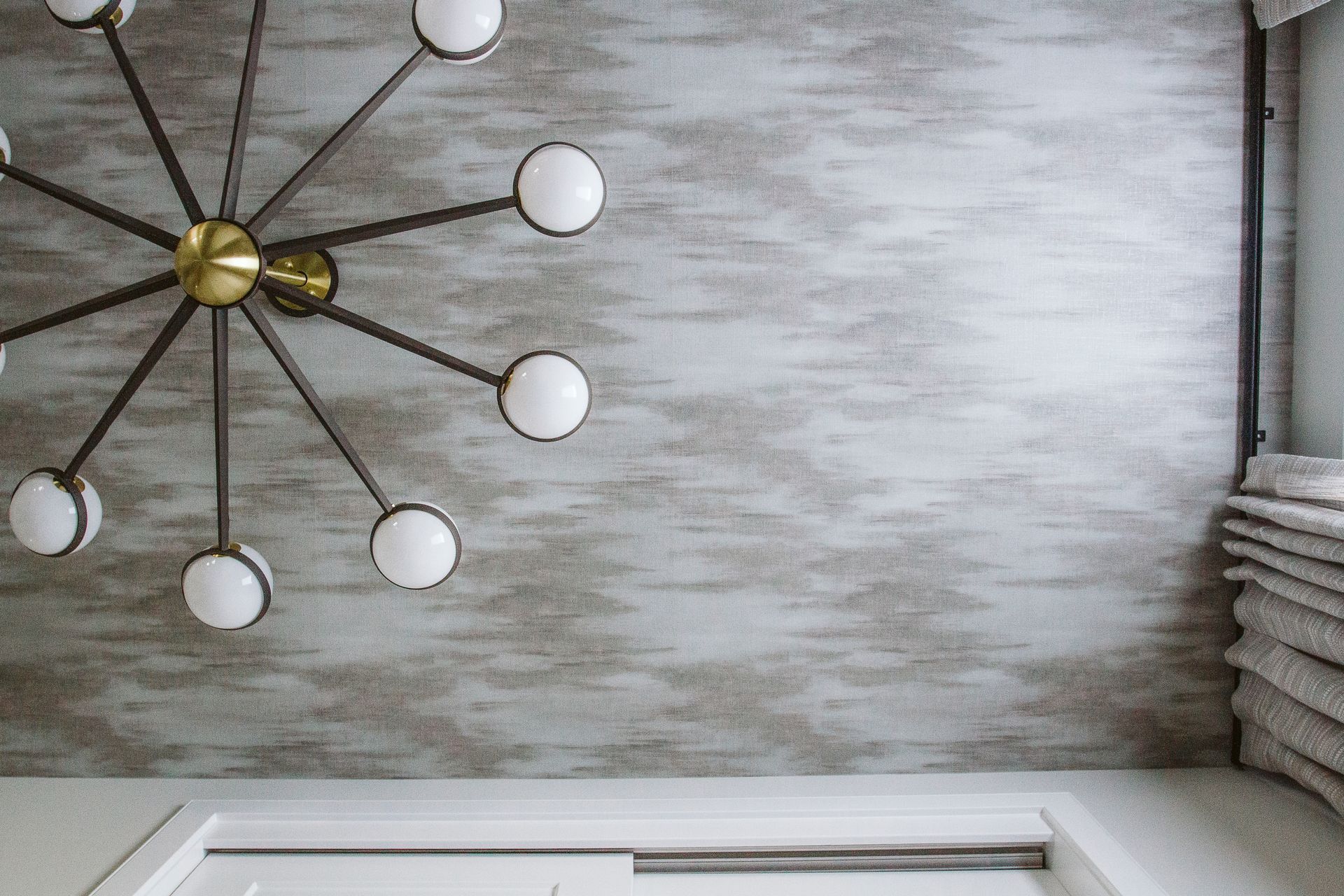 A chandelier is hanging from the ceiling in a bathroom.
