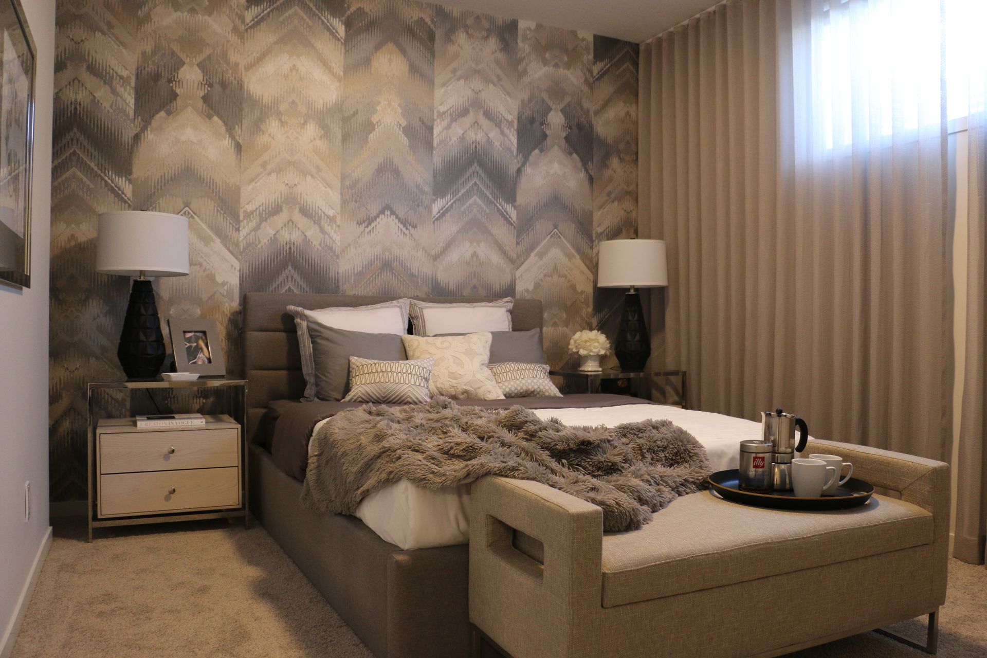 A bedroom with a large bed and a bench