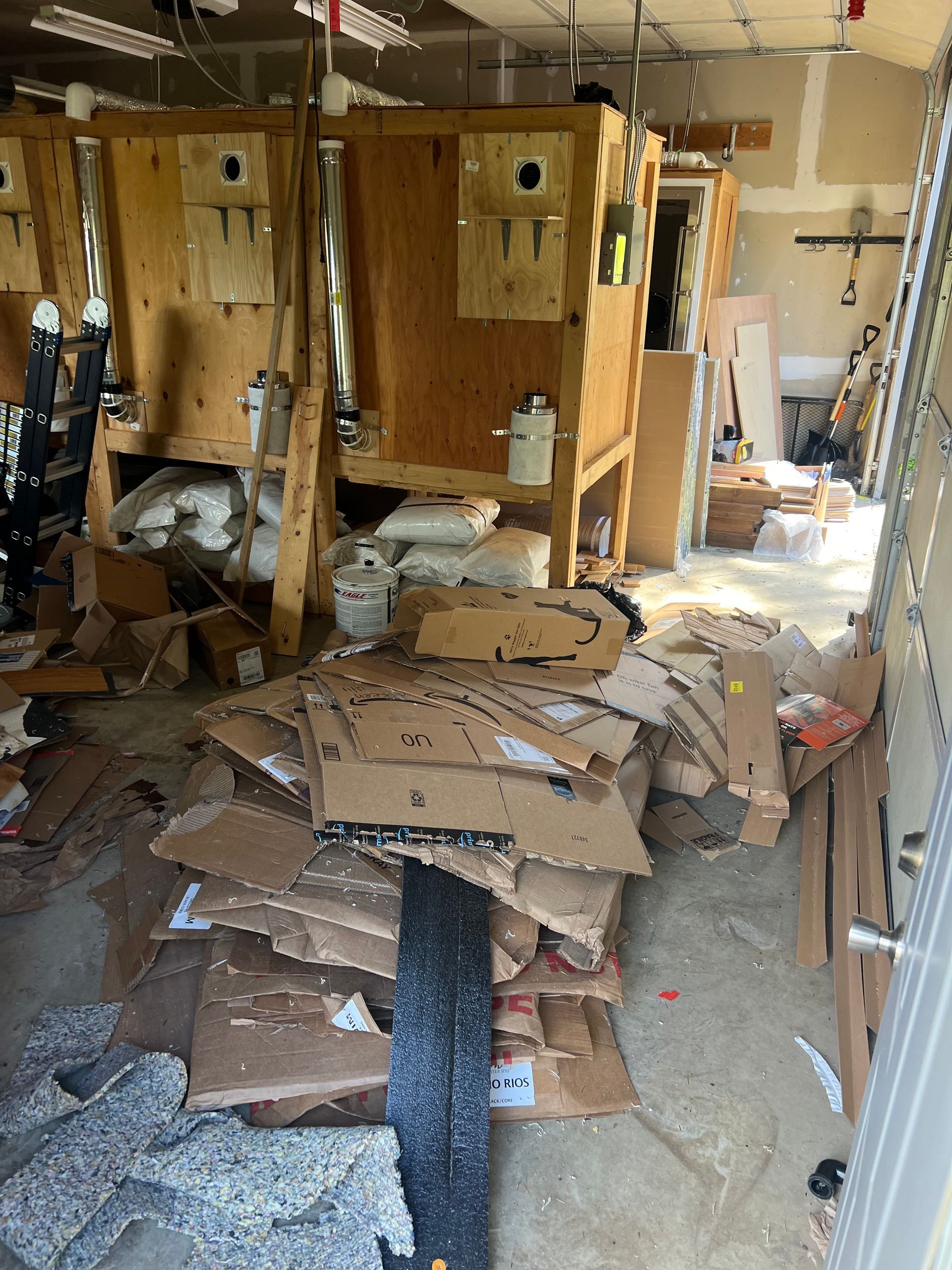 A room with a lot of cardboard boxes on the floor.