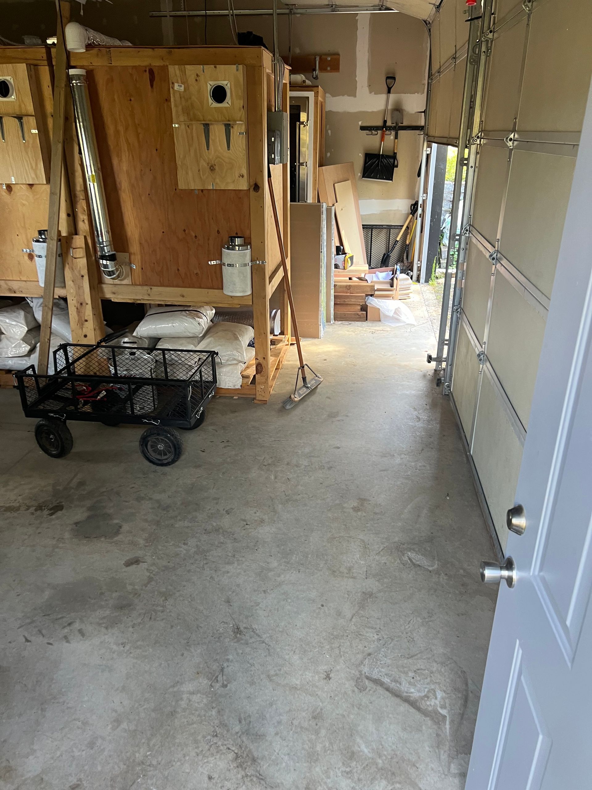 A wagon is sitting in a garage next to a garage door.