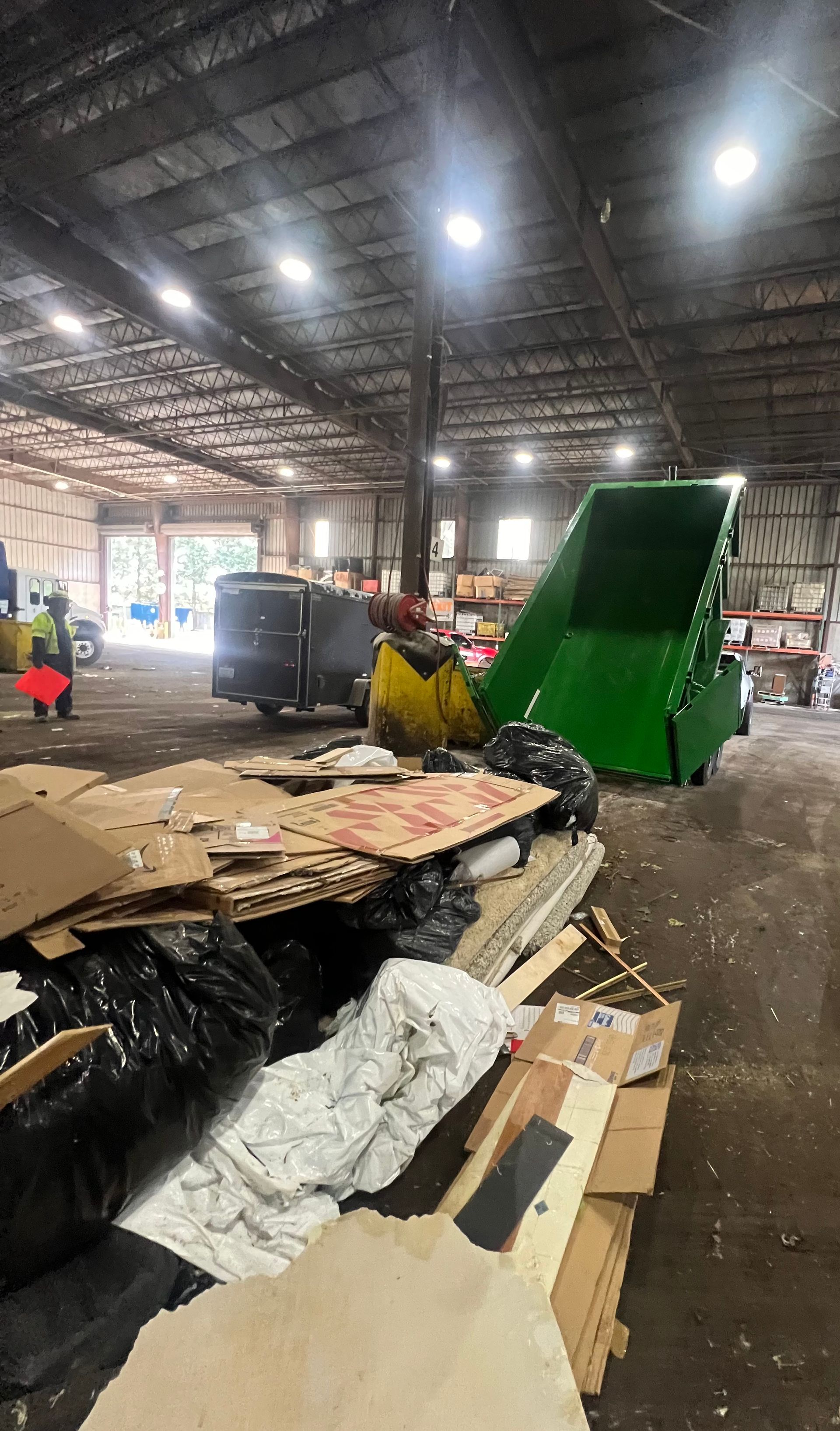 A large warehouse filled with lots of cardboard and trash.