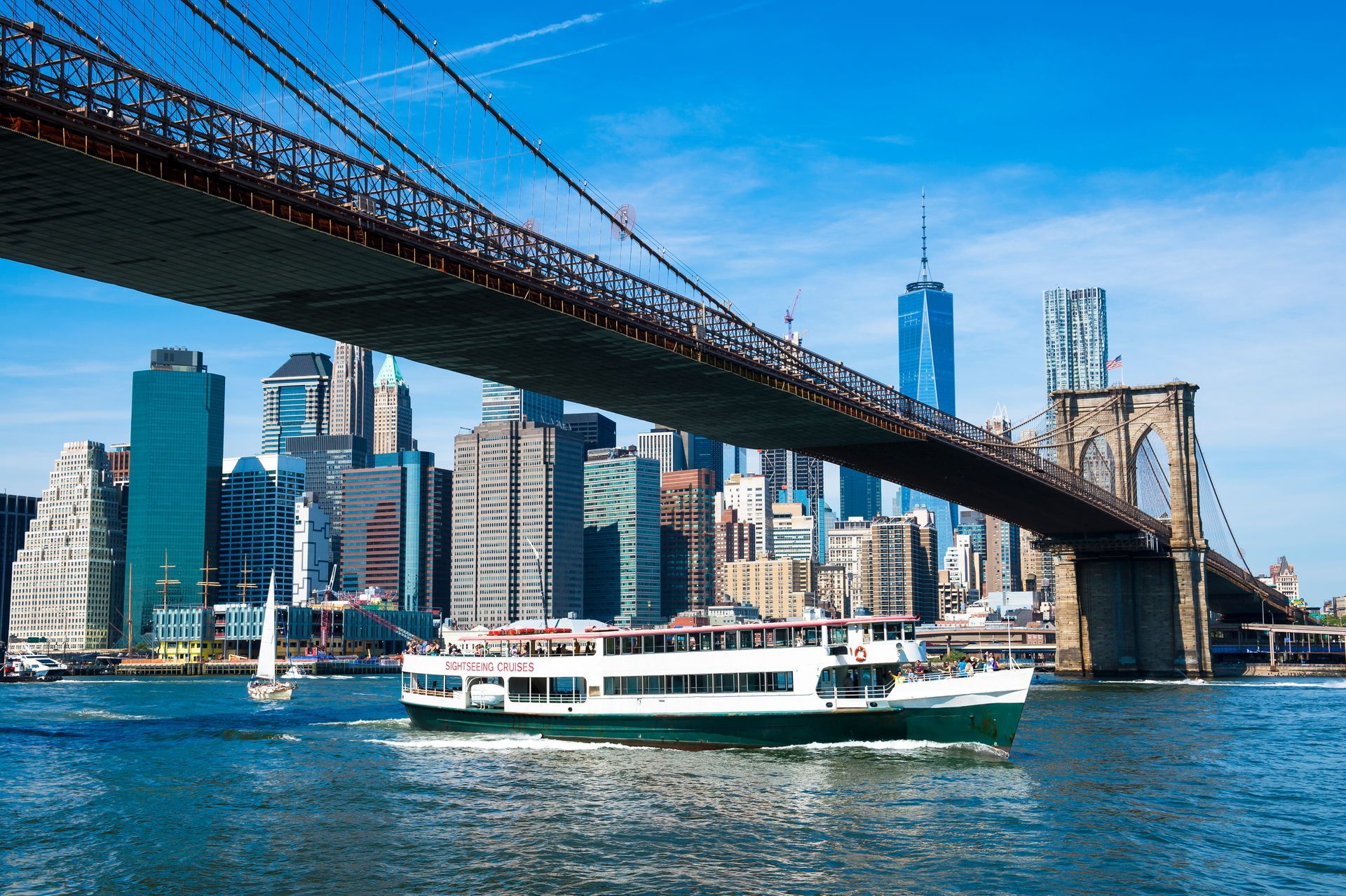 A boat is going under a bridge in new york city