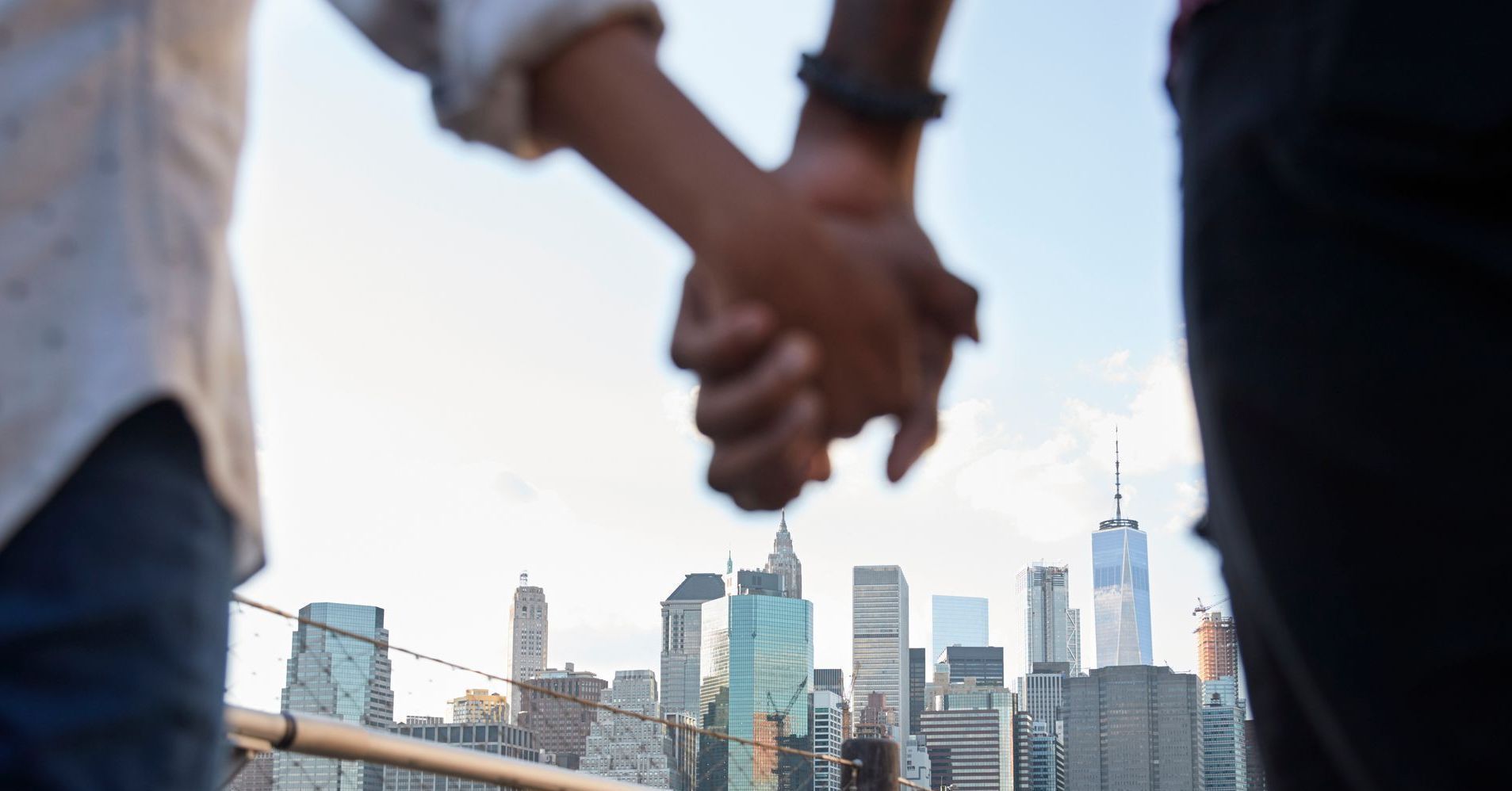 A couple is holding hands in front of a city skyline.