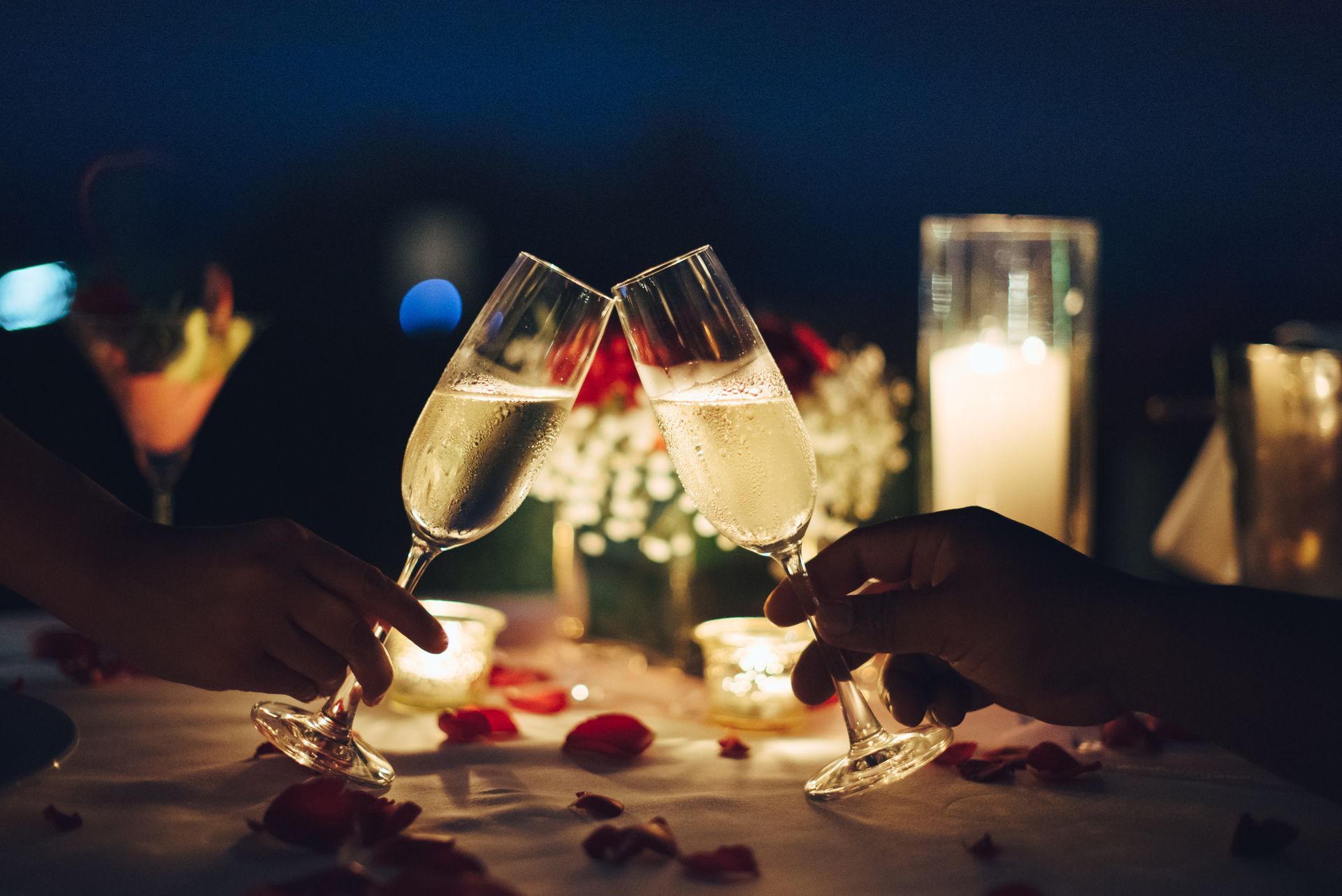 A couple is toasting with champagne glasses at a table.