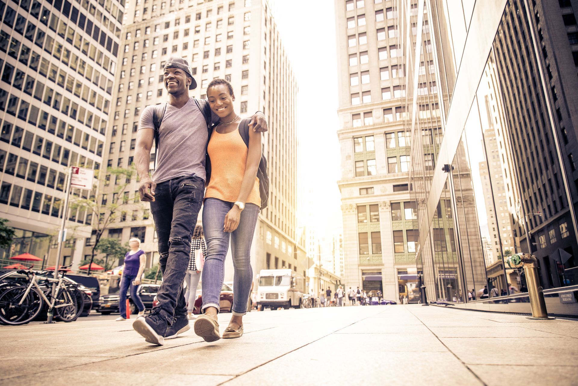 A man and a woman are walking down a city street.