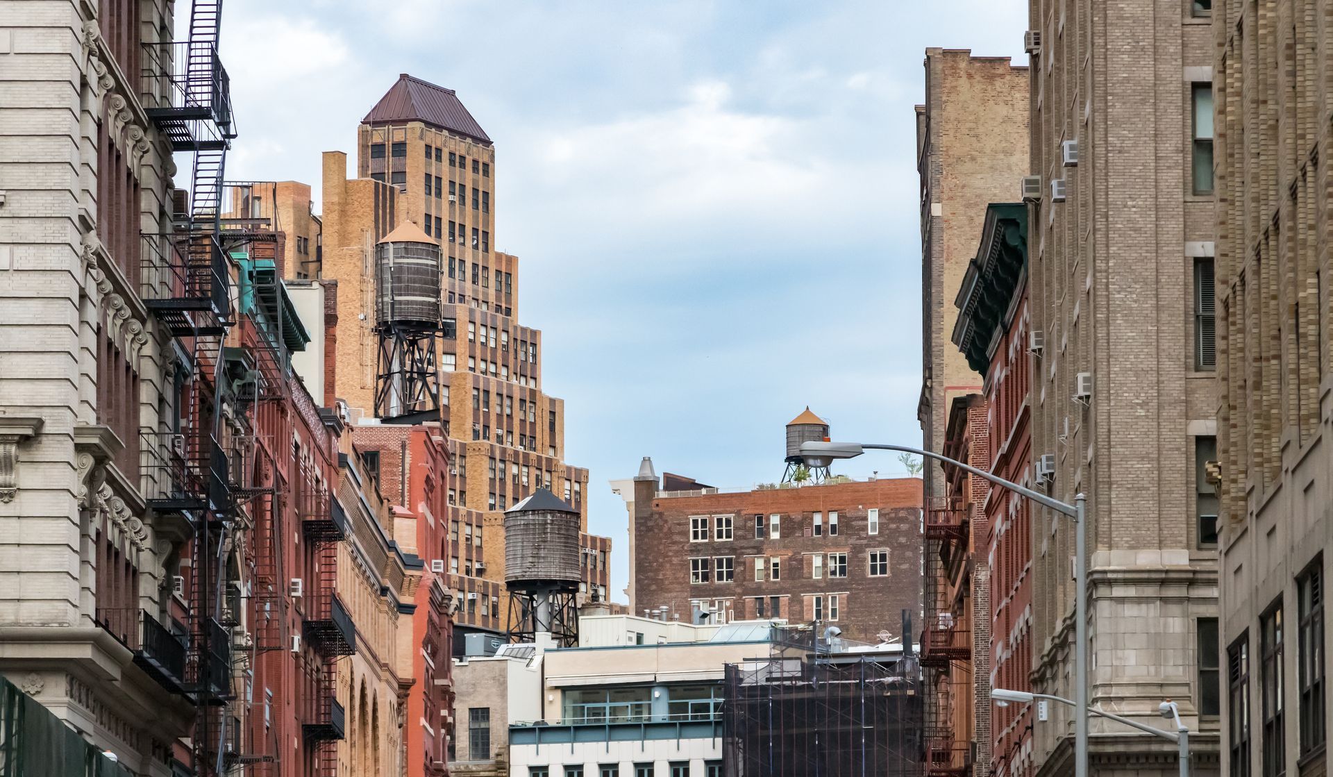 A city street with a lot of buildings and a fire escape.