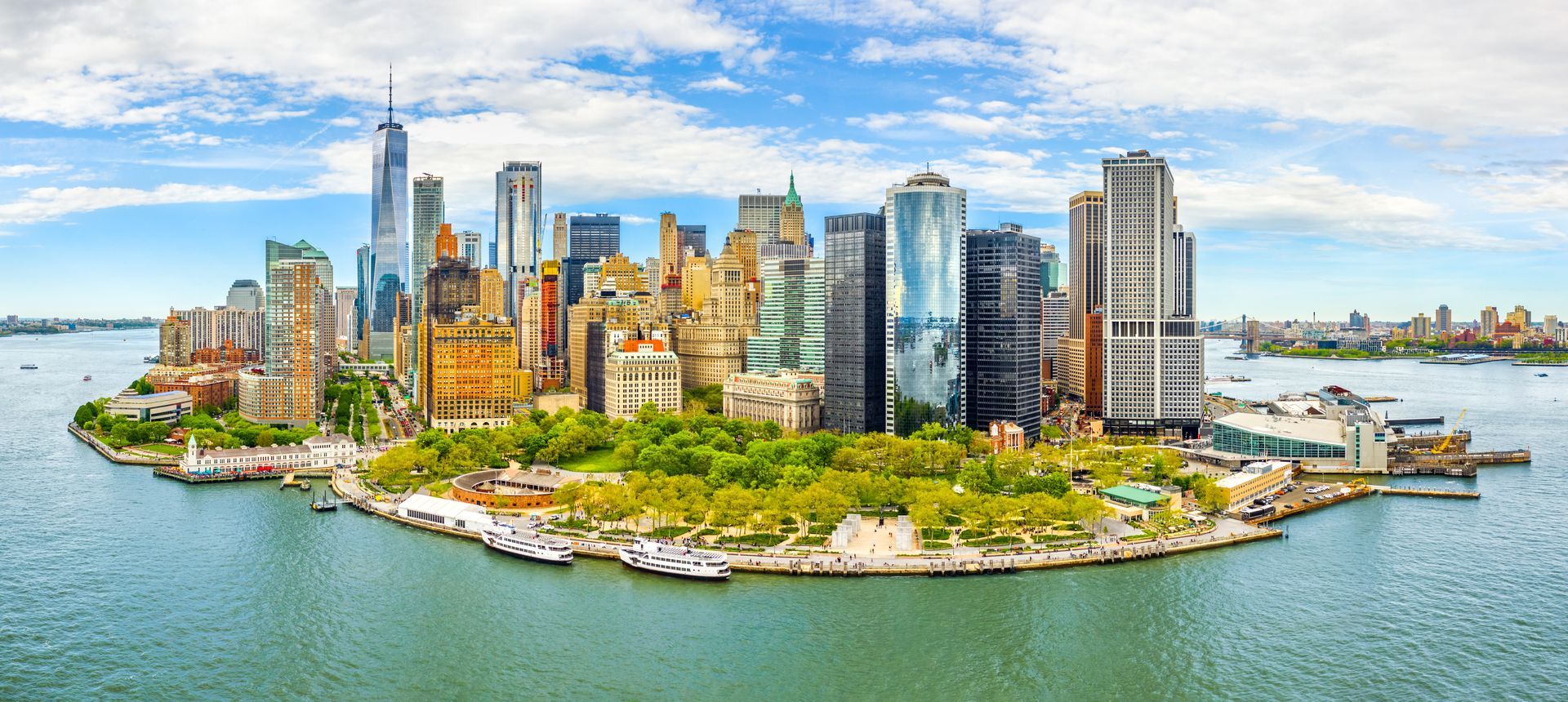 View of the New York City skyline from across the water on a sunny day.