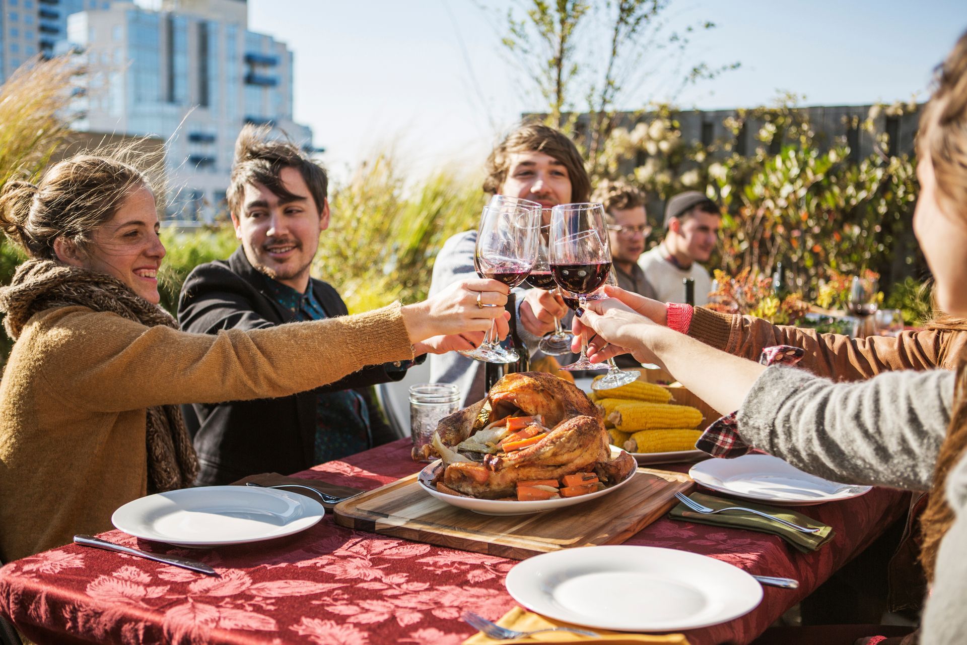 A group of people are sitting at a table toasting with wine glasses.