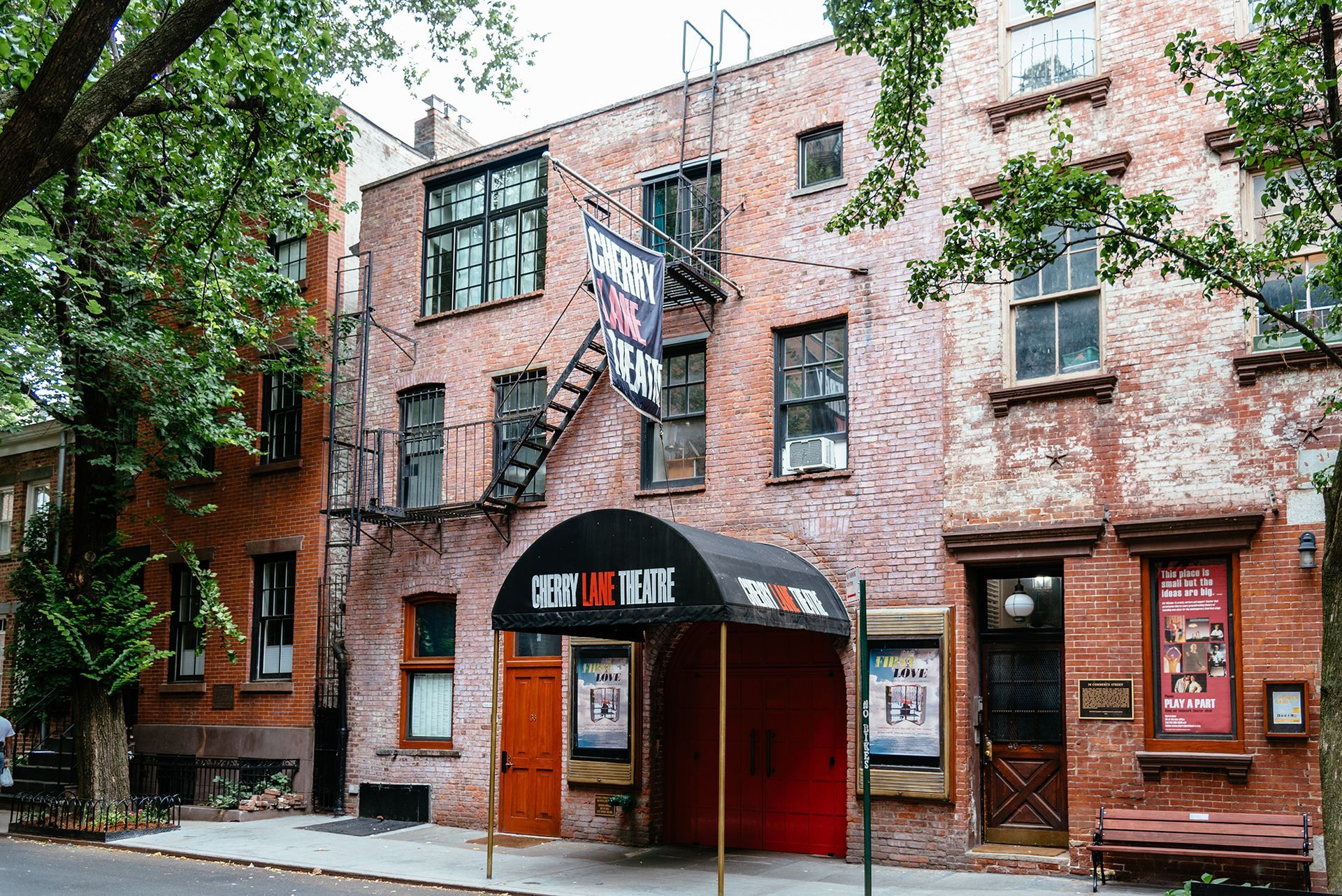 a brick building with a red awning and a fire escape .