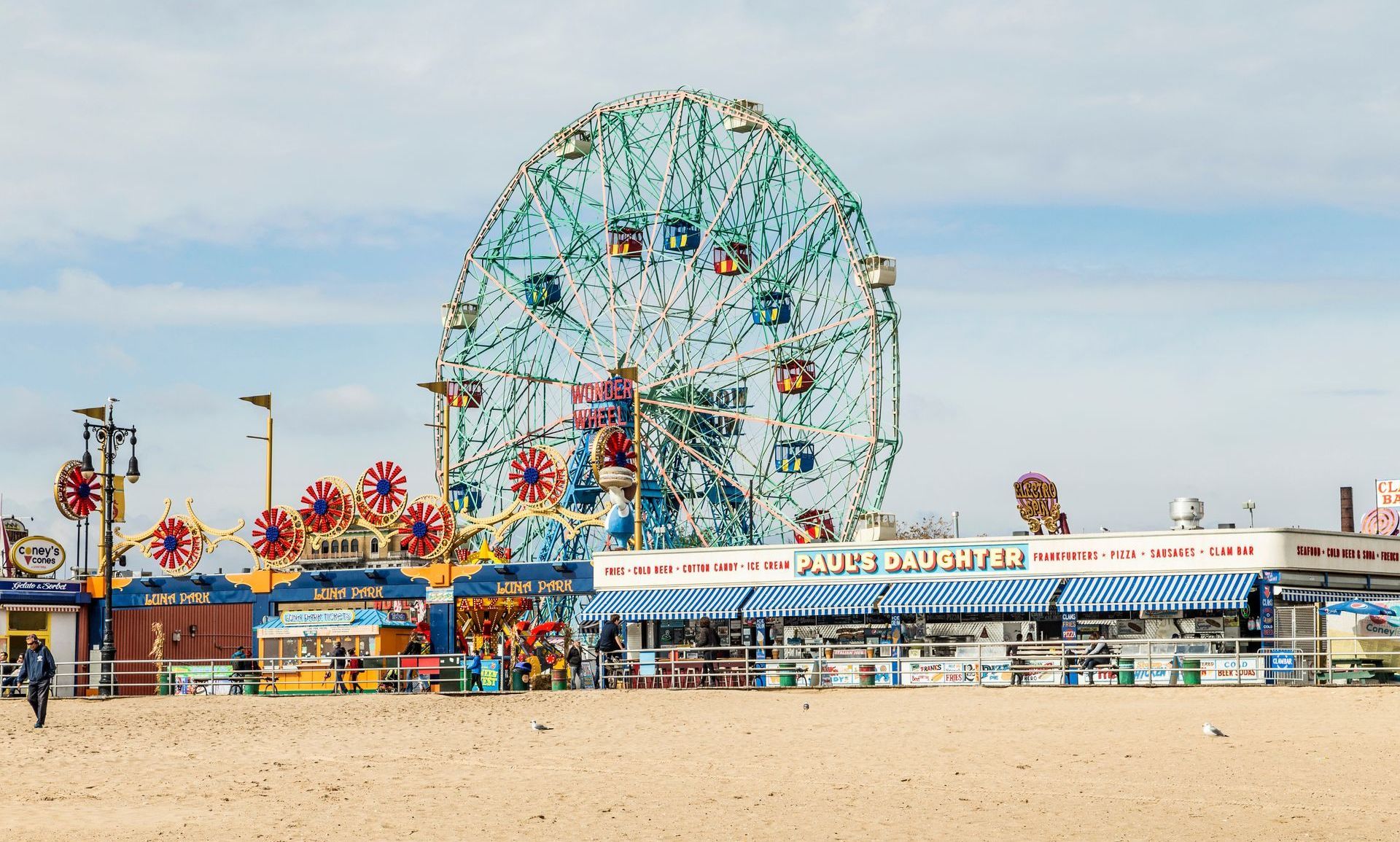 A ferris wheel is sitting on top of a sandy beach.